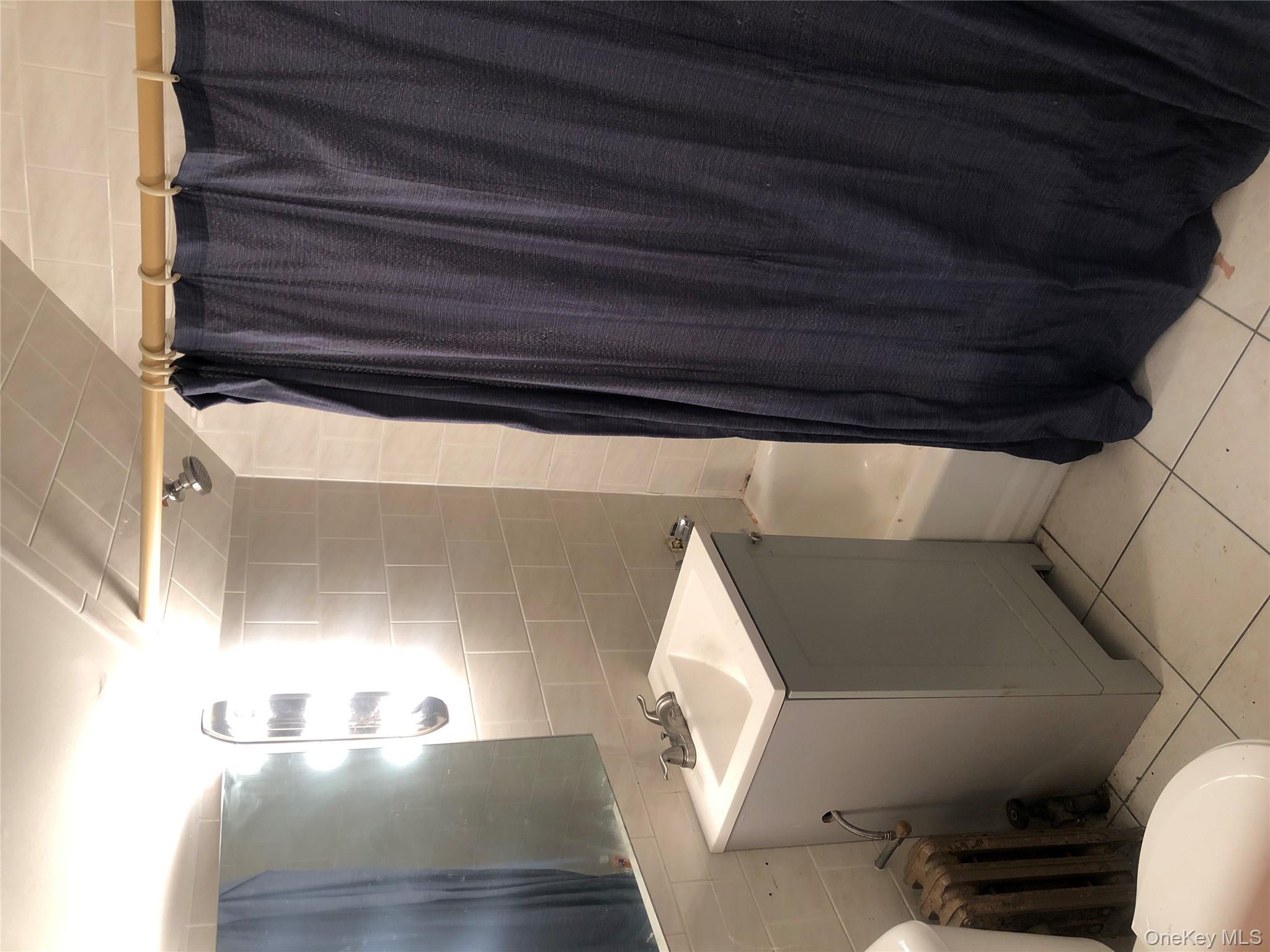 801 East Broadway, Unit F Long Beach, NY 11561 - Photo 11 of 11 a bathroom with a sink and mirror