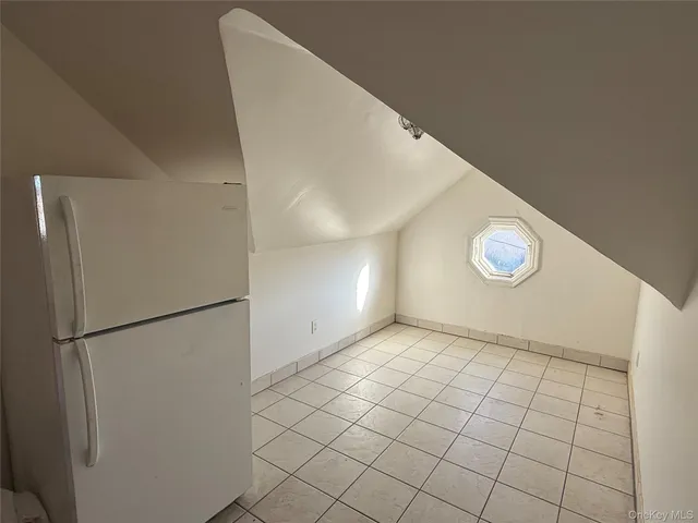 a view of an empty room with a refrigerator