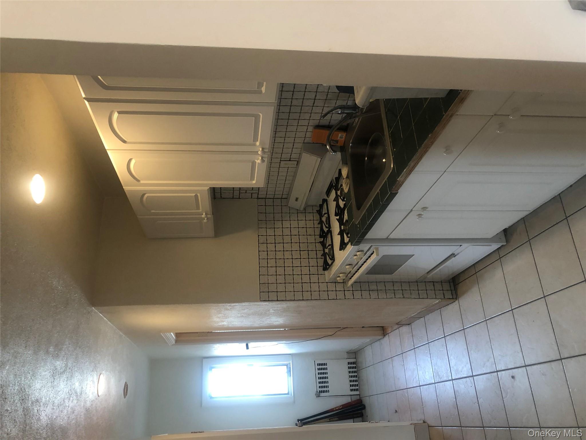 801 East Broadway, Unit F Long Beach, NY 11561 - Photo 10 of 11 a kitchen with a sink and cabinets