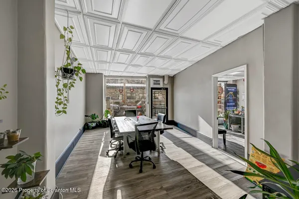 a view of a hallway with wooden floor and a bathroom
