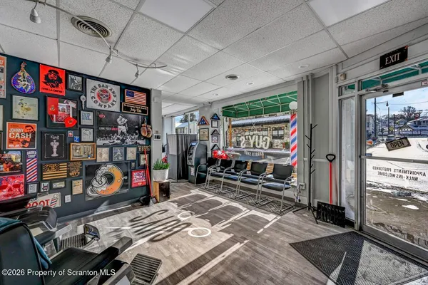 a view of a hallway with wooden floor and a bathroom