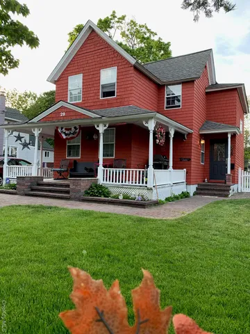 a front view of a house with a garden and yard