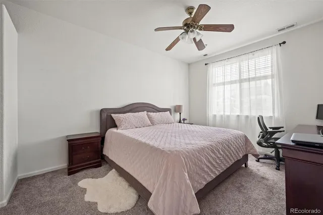 a bedroom with a bed a chandelier and a window