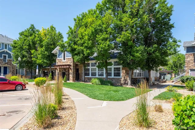 a front view of a house with a garden and trees