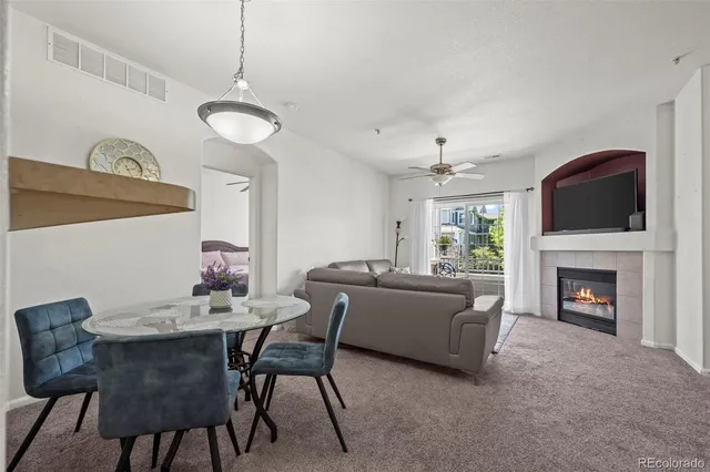 a living room with furniture a fireplace and a chandelier