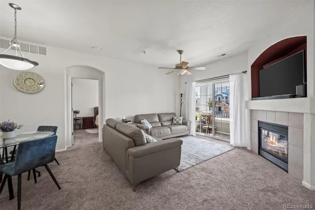 a living room with furniture a fireplace and a flat screen tv