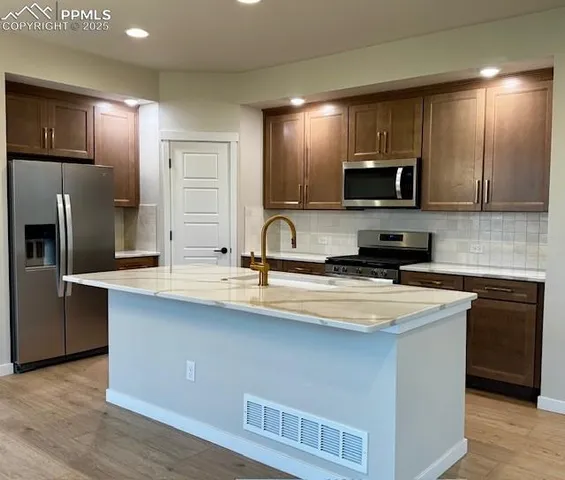 a kitchen with stainless steel appliances a sink stove and refrigerator