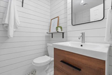 a bathroom with a sink a toilet and mirror