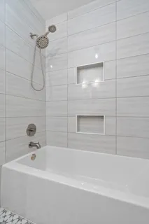 a bathroom with a bath tub with a shower