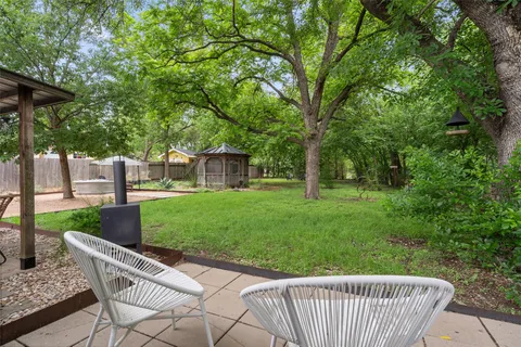 a view of a chair and table in the backyard