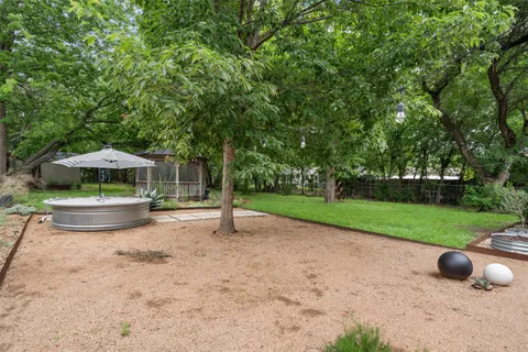 a view of a garden with a bench and trees