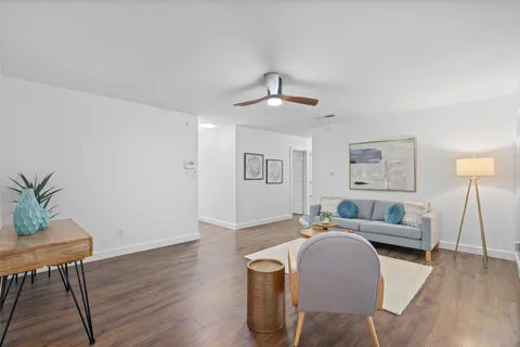 a living room with furniture and a wooden floor
