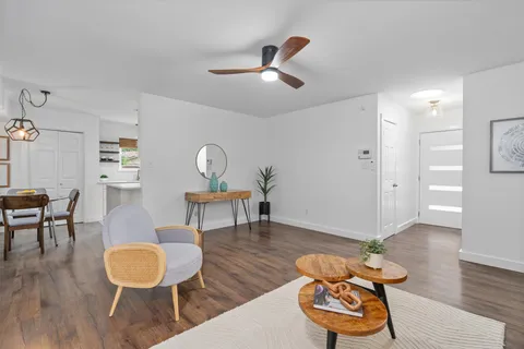 a living room with furniture and a wooden floor