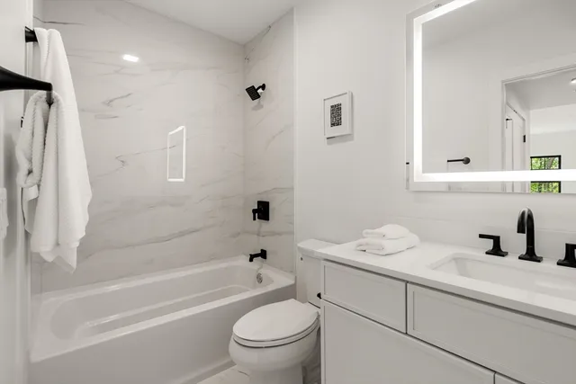 a bathroom with a sink toilet vanity and shower