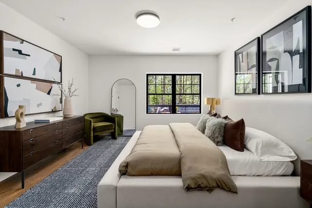 a bedroom with a bed window and mirror