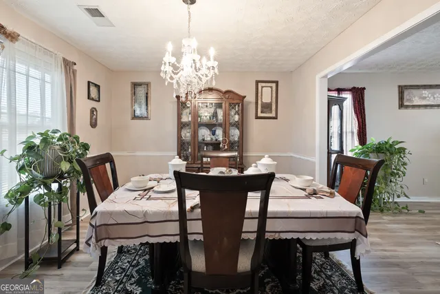 a view of a dining room with furniture and chandelier