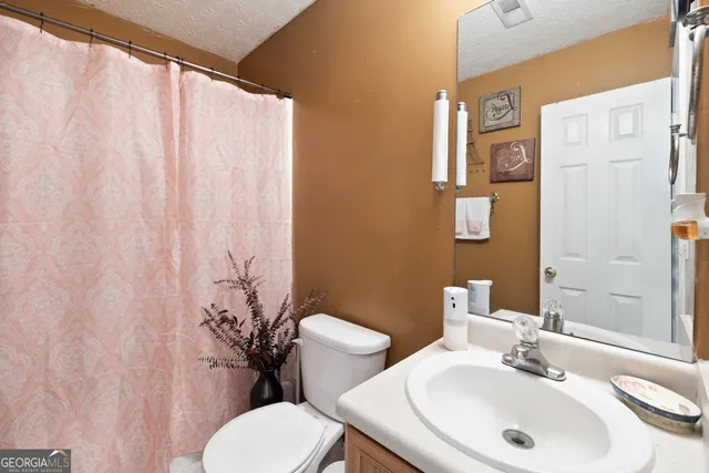 a bathroom with a sink a toilet and a mirror