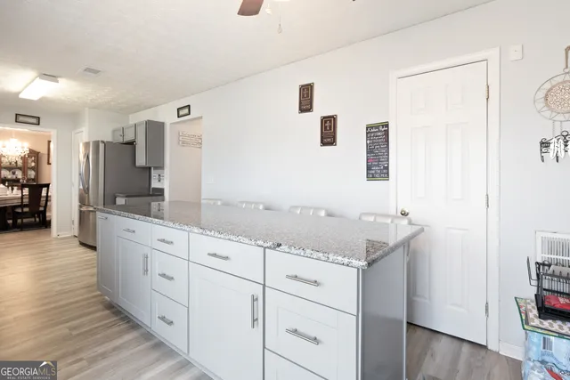 a spacious bathroom with a granite countertop sink a mirror and a shower