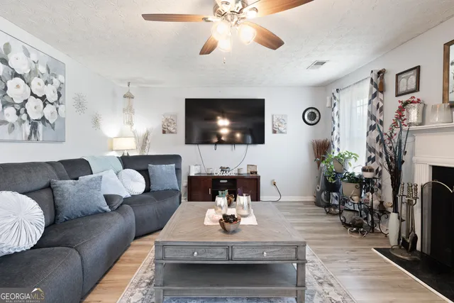 a living room with furniture a flat screen tv and a fireplace