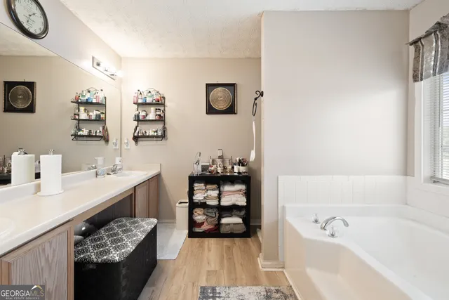 a bathroom with a tub sink and mirror