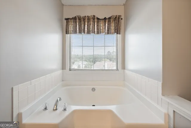 a bathroom with a bathtub and a window