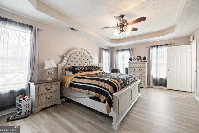 a spacious bedroom with a bed and a chandelier