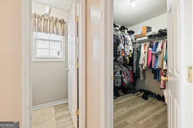 a view of walk in closet with clothes