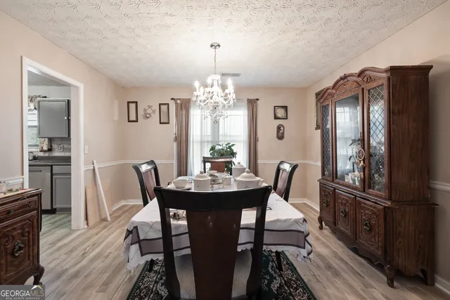 a dining room with furniture a chandelier and wooden floor