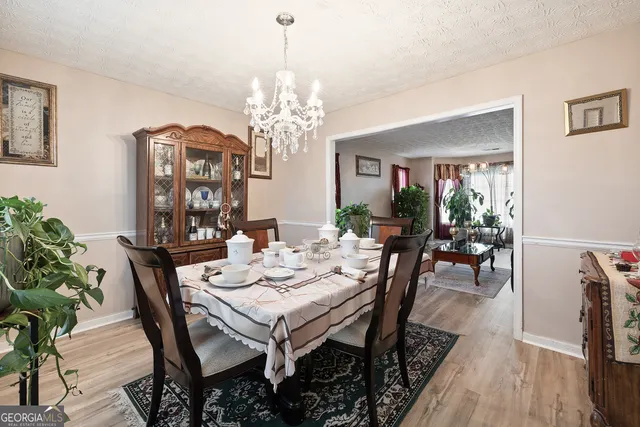 a view of a dining room with furniture a chandelier and wooden floor