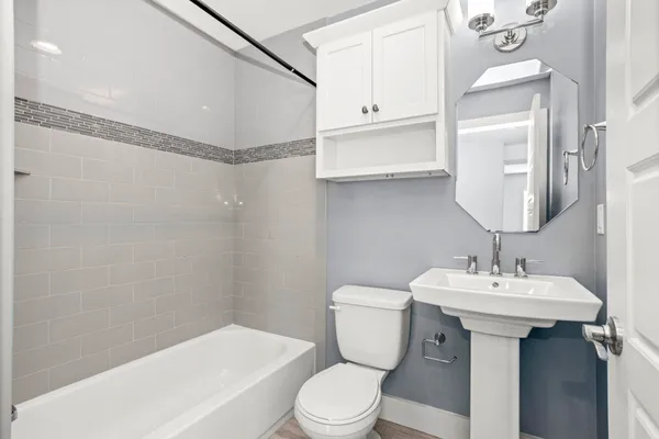 a bathroom with a sink a toilet and shower