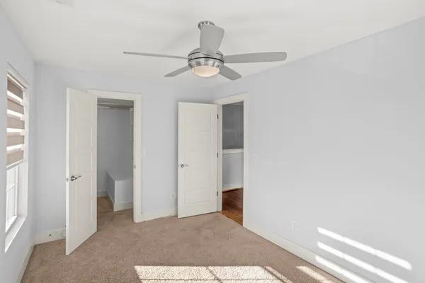a view of a livingroom with a ceiling fan and window