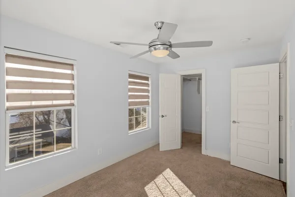 a view of empty room with windows and ceiling fan