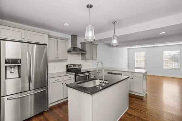 a kitchen with stainless steel appliances granite countertop a sink stove a refrigerator and a refrigerator
