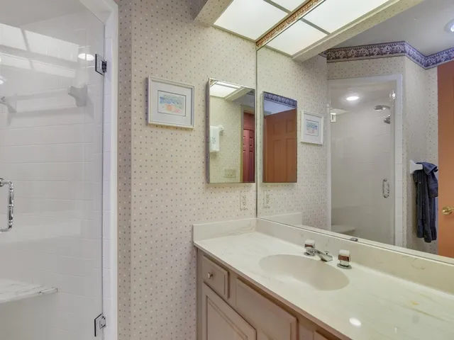 a bedroom with a bed and large mirror on the dresser