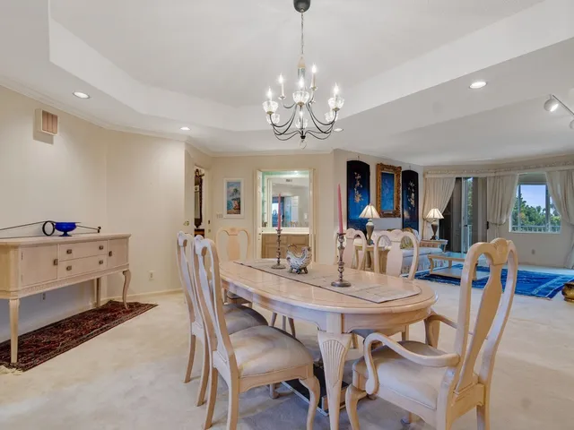 a view of a dining room with furniture a chandelier and wooden floor