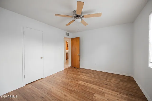 a view of an empty room with wooden floor
