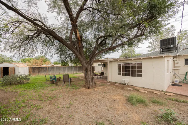 a backyard of a house with table and chairs