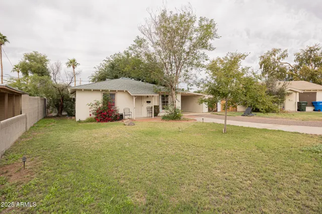 a front view of a house with a yard and trees
