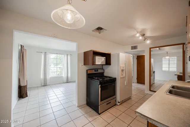 a kitchen with stainless steel appliances granite countertop a refrigerator and a sink
