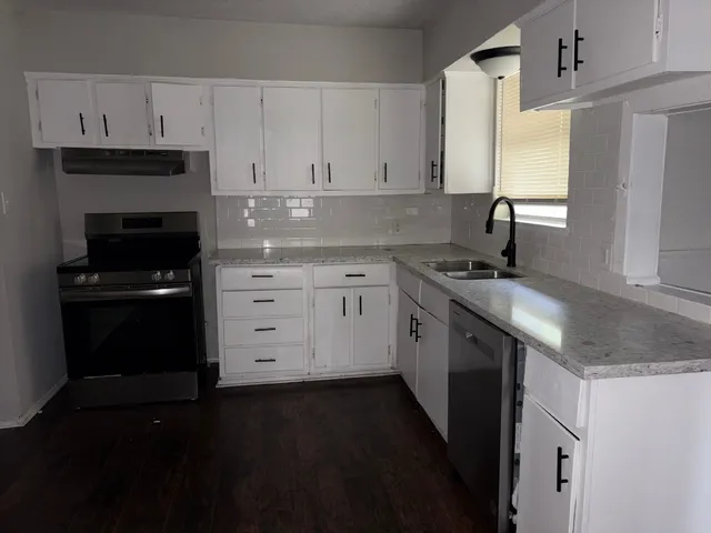 a kitchen with a sink stove and cabinets