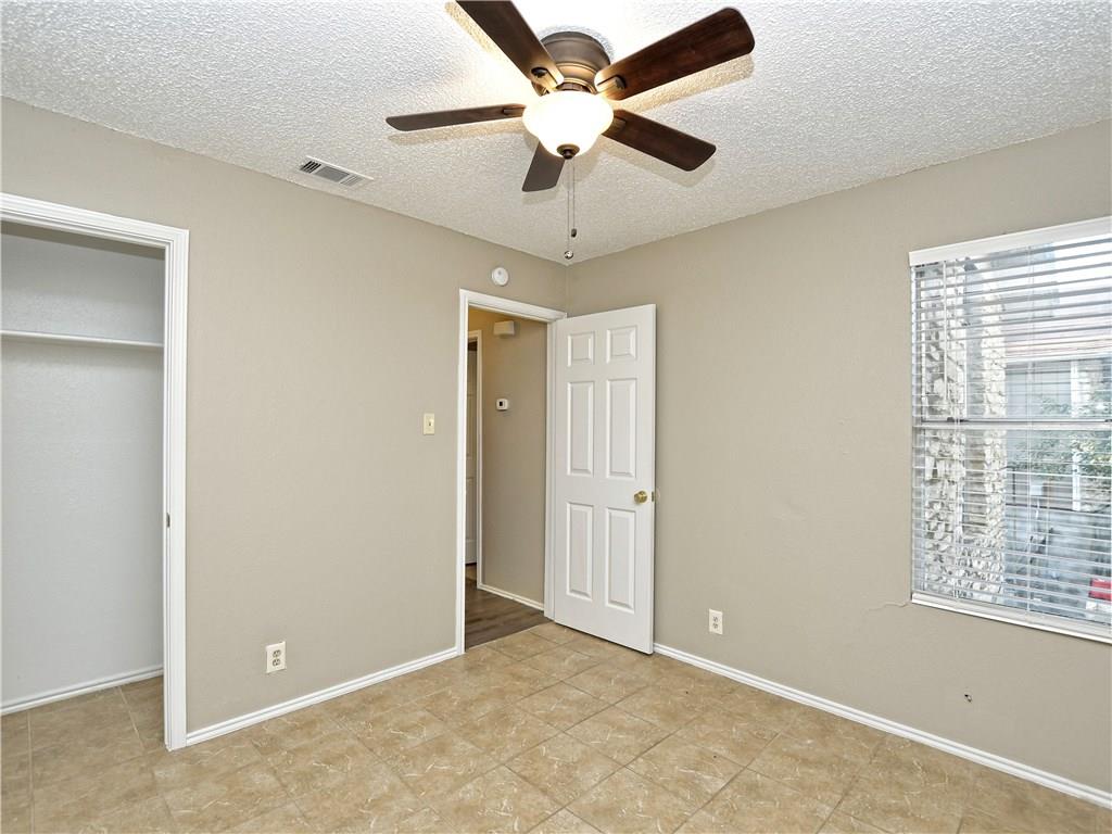 5401 Spring Meadow Road, Unit B Austin, TX 78744 - Photo 15 of 21 A comfortable bedroom with a ceiling fan and tile flooring awaits your personal touch.