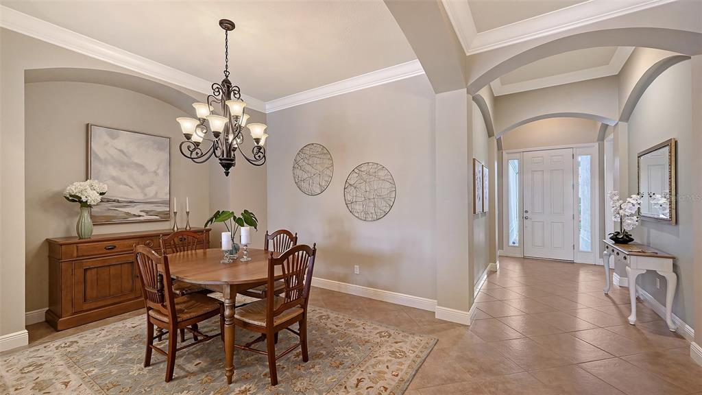 14718 Secret Harbor Place Lakewood Ranch, FL 34202 - Photo 11 of 73 a view of a dining room with furniture a chandelier and wooden floor