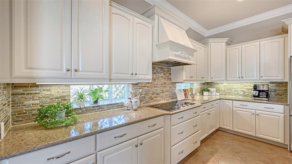 14718 Secret Harbor Place Lakewood Ranch, FL 34202 - Photo 23 of 73 a kitchen with granite countertop white cabinets and white stainless steel appliances