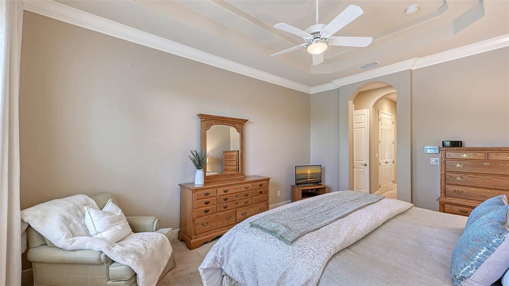 14718 Secret Harbor Place Lakewood Ranch, FL 34202 - Photo 28 of 73 a bedroom with a bed and a chandelier