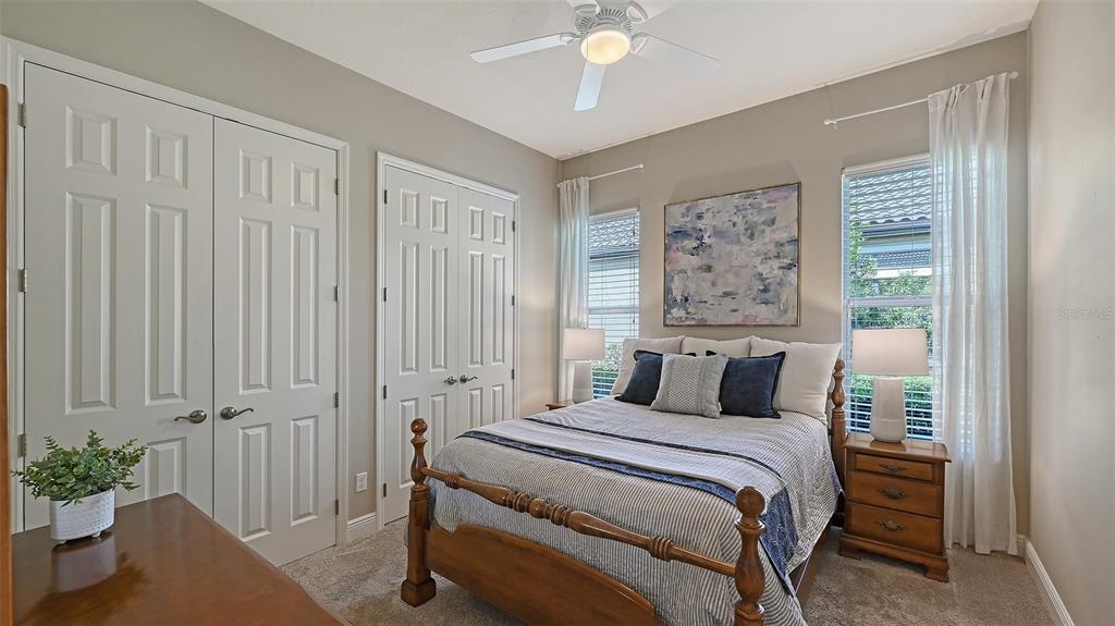 14718 Secret Harbor Place Lakewood Ranch, FL 34202 - Photo 31 of 73 a bedroom with a large bed and a chandelier