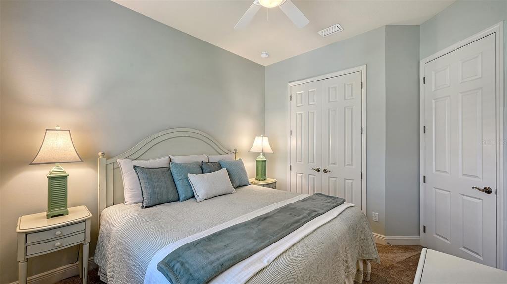 14718 Secret Harbor Place Lakewood Ranch, FL 34202 - Photo 34 of 73 a bedroom with a bed and a lamp