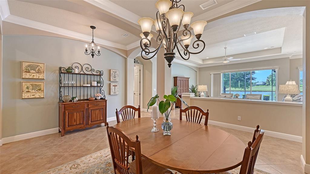 14718 Secret Harbor Place Lakewood Ranch, FL 34202 - Photo 10 of 73 a view of a dining room with furniture wooden floor and chandelier