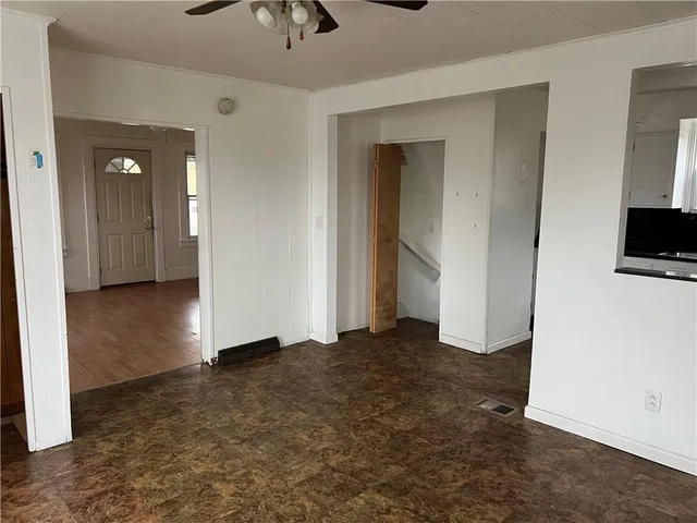 an empty room with closet and a chandelier fan