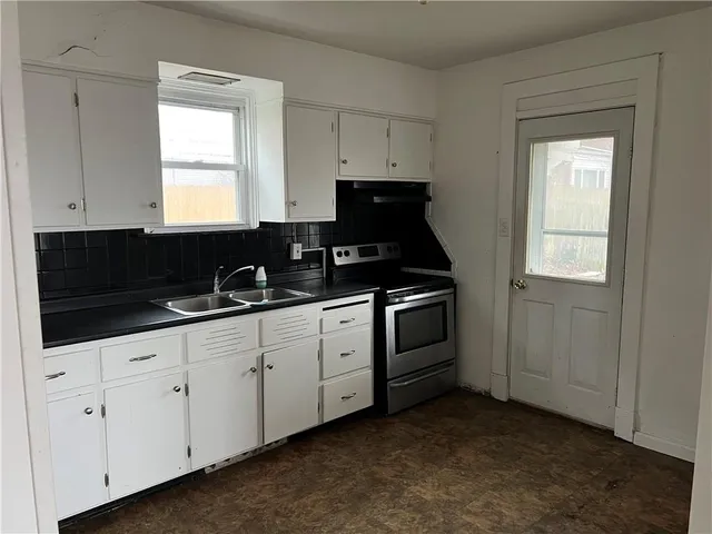 a kitchen with granite countertop white cabinets and sink
