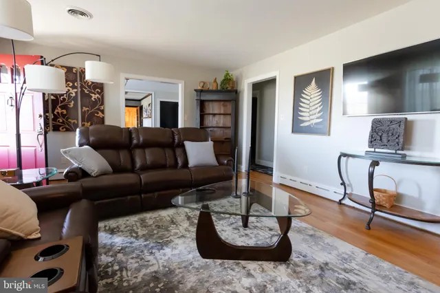 a living room with furniture and a wooden floor